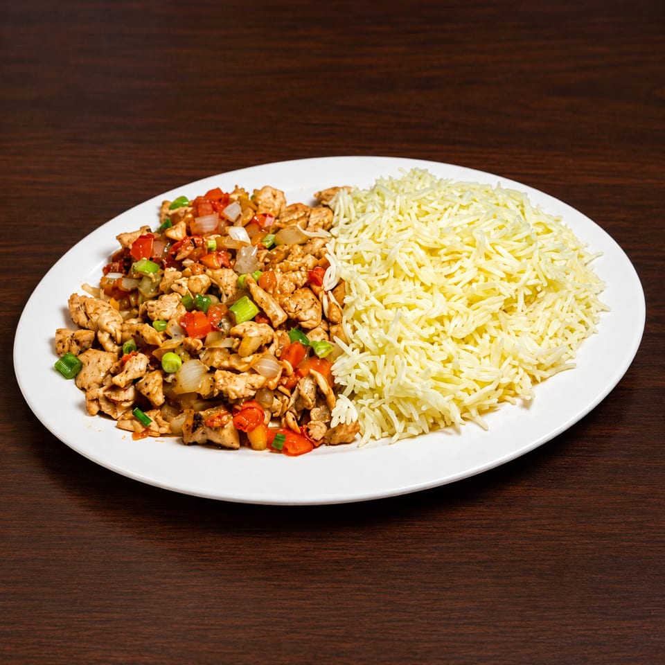 Chicken stir-fry with peppers and onions, served alongside a mound of white rice on a plate.