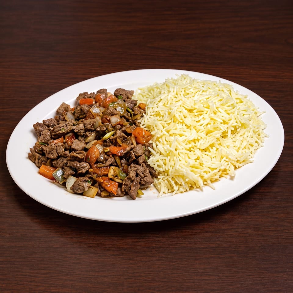 A white oval plate holds a serving of beef stir-fry with vegetables and a mound of white rice.